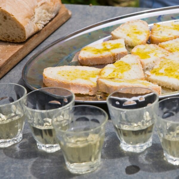 Aperitivo español con pan tostado y chupitos de licor.