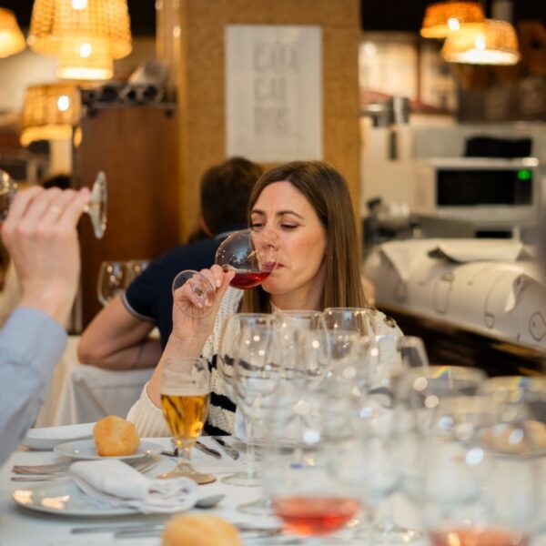 Mujer degustando vino en restaurante elegante.