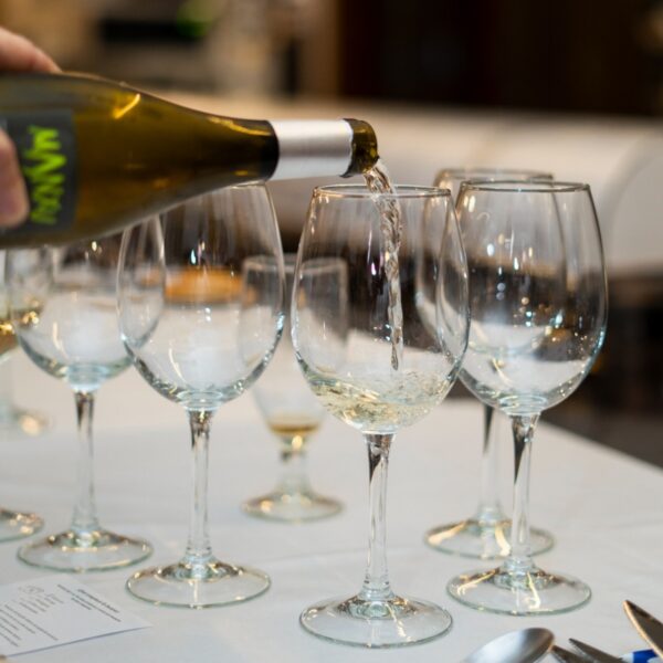 Servicio de vino blanco en copas elegantes.